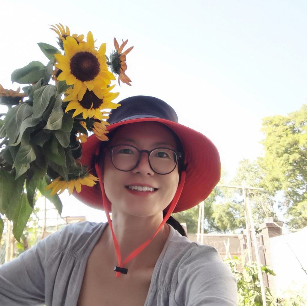 Qigong teacher smiling with sunflowers